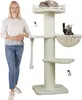 A woman stands next to a tall, cream-colored cat tree with multiple platforms and hanging toys. Two cats are visible on the cat tree. Podgląd zdjęcia produktu