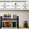A microwave rack with various kitchen items on it, placed above a microwave. Produktbild-Vorschau