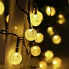 A close-up view of string lights with round, textured bulbs emitting a warm yellow glow. Voir les images du produit