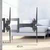 A TV wall mount is shown attached to a wall, extending outwards with its arms. A couch is visible in the background. Voir les images du produit