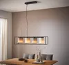 A modern dining room with a rectangular chandelier hanging over a wooden table. Produktbild-Vorschau