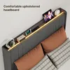A close-up view of a modern upholstered bed headboard with integrated storage and lighting. Anteprima dell’immagine prodotto