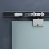 A close-up view of a sliding glass door hardware system mounted on a wall. Produktbild-Vorschau