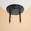 Close-up view of the base of a white spherical light fixture, showing the black mounting hardware and two black ground stakes. Produktbild-Vorschau