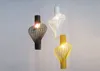 Three modern pendant lights in different colors hang against a white background. Produktbild-Vorschau