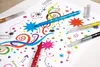 Glitter pens are used to draw colorful patterns and stars on a white sheet of paper. Podgląd zdjęcia produktu
