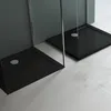 Two black shower trays with glass panels in a minimalist bathroom setting. Produktbild-Vorschau