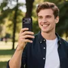 A man is taking a selfie in a park with a phone. Anteprima dell’immagine prodotto