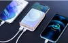 Three smartphones are shown, two of which are charging. One is wirelessly charging on a white power bank, and another is plugged into a power bank with a cable. Podgląd zdjęcia produktu
