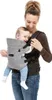 A woman is carrying a baby in a baby carrier. Podgląd zdjęcia produktu