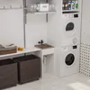 A laundry room with a washing machine and dryer stacked, a sink, laundry baskets, and shelves with cleaning supplies. Anteprima dell’immagine prodotto