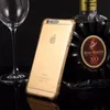 A gold iPhone case is placed next to a glass of wine and a bottle of Remy Martin cognac. Produktbild-Vorschau