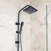 A black shower fixture with a square showerhead and a handheld showerhead mounted on a marble-tiled wall. Produktbild-Vorschau