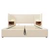 A beige upholstered bed frame with integrated nightstands and reading lights. Produktbild-Vorschau