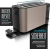 A close-up, angled view of a bronze and black toaster with marketing text overlays. Produktbild-Vorschau