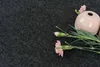 A pink vase with pink carnations on a dark gray textured surface. Produktbild-Vorschau
