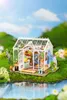 A miniature greenhouse model is set in a lush, green outdoor environment with a body of water in the foreground. Anteprima dell’immagine prodotto