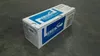 A cardboard box containing a toner cartridge is placed on a textured gray surface. Voir les images du produit