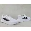 A pair of white Adidas running shoes with black stripes on a light gray concrete-like background. Produktbild-Vorschau
