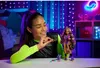 A young girl is playing with a Monster High doll in a room decorated with purple and blue lights. Náhľad obrázku produktu