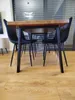 A dining table with chairs in a room with wooden floors and large windows. Anteprima dell’immagine prodotto