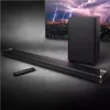 A soundbar, subwoofer, and remote are displayed in front of a television showing a lightning storm. Produktbild-Vorschau