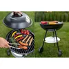 A split image showing a Blaupunkt grill. The left side shows a hand using tongs to place food on the grill, with the lid open. The right side shows the grill with food cooking on it, set up on its stand. Produktbild-Vorschau