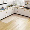 A modern kitchen with white cabinets and a wooden floor, featuring two light-colored floor mats in front of the cabinets. Produktbild-Vorschau