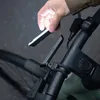 A person is attaching a light to a bicycle handlebar. Voir les images du produit