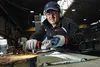 A man is using an angle grinder in a workshop. Produktbild-Vorschau