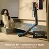 A dog sits on stairs next to a vacuum cleaner that is shown cleaning under a low surface. Produktbild-Vorschau