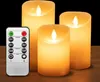 Three LED candles of varying heights are displayed on a wooden surface, with a remote control in the foreground. Podgląd zdjęcia produktu