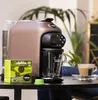 A Lavazza coffee machine with a box of coffee capsules and a cup of coffee on a table. Podgląd zdjęcia produktu