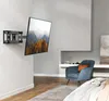 A TV wall mount with a TV attached, in a modern living room setting. Náhľad obrázku produktu
