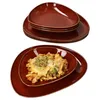 A stack of brown plates and a plate with food. Produktbild-Vorschau