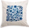 A white pillow with a blue folk art design of a bird and foliage. Produktbild-Vorschau