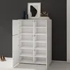 A white shoe cabinet with multiple shelves is shown in a room with a dark gray wall and a light gray floor. Decorative items are on top of the cabinet. Produktbild-Vorschau