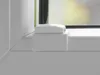 A close-up view of a white window fitting, likely a mounting bracket or clamp, attached to a white window sill. Produktbild-Vorschau