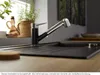 A kitchen sink area with a faucet, plants, and a bottle on a windowsill. Produktbild-Vorschau