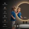 A child is brushing their teeth in front of a round LED mirror with a light ring. Anteprima dell’immagine prodotto