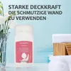 Weiße Flasche Small Roller-Multi Color Mini Paint mit rosa Etikett, neben einer Vase mit weißen Blumen und weißen gerollten Handtüchern Anteprima dell’immagine prodotto