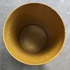 Top-down view of the inside of an empty, mustard-yellow metal barrel. Anteprima dell’immagine prodotto
