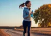 A woman is running outdoors with a water bottle. Náhľad obrázku produktu