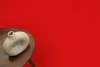 A donut-shaped vase sits on a wooden table against a red background. Náhled obrázku produktu