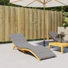 A patio scene with a wooden fence, a lounge chair with a gray cushion, a small wooden table, and an umbrella. Voir les images du produit