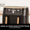 Close-up of the top control panel and handles of a black and gold air fryer, with a kitchen background. Produktbild-Vorschau