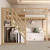 A wooden bunk bed with stairs and storage, set up in a child's room with decorative pillows and blankets. Náhled obrázku produktu