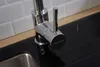 A close-up of a modern kitchen faucet with a black countertop and white subway tile backsplash. Produktbild-Vorschau