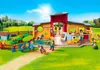 A Playmobil dog hotel playset with figures and dogs in a grassy outdoor setting. Produktbild-Vorschau