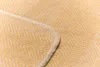 A close-up view of a textured yellow blanket with a herringbone pattern and a stitched edge. Produktbild-Vorschau